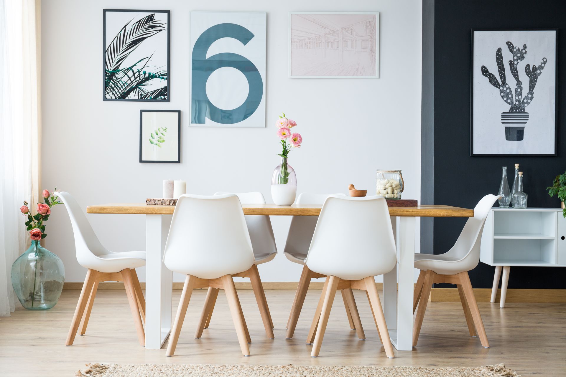 Haven 30 home design - A dining room with a table and chairs and paintings on the wall.