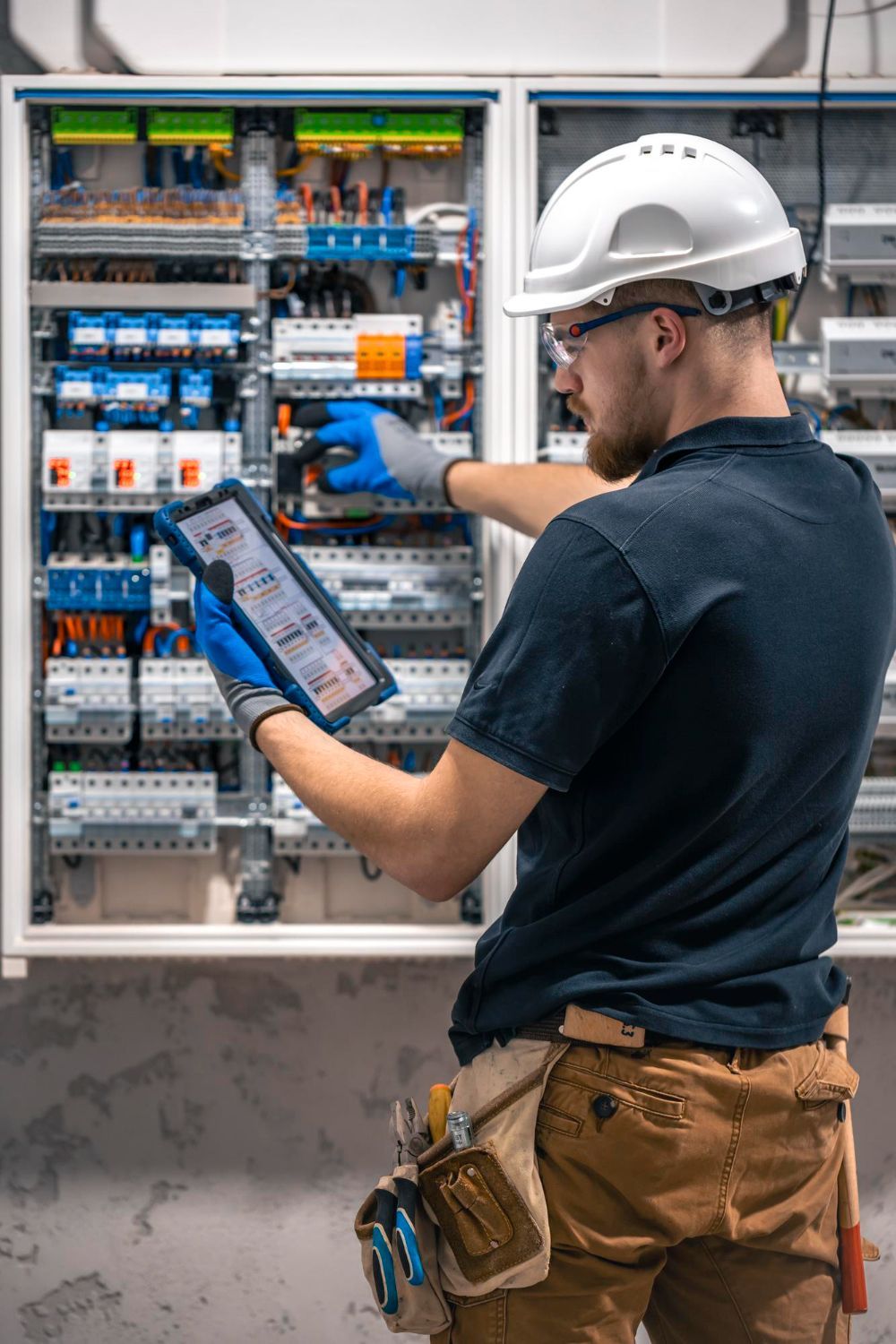 A man and a woman are standing in a field holding hands.