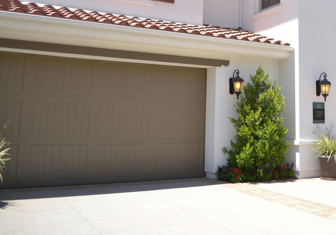 A white house with a brown garage door