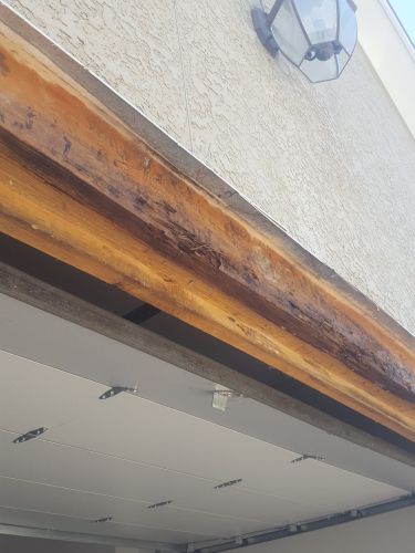 A close up of a wooden beam on the side of a building.