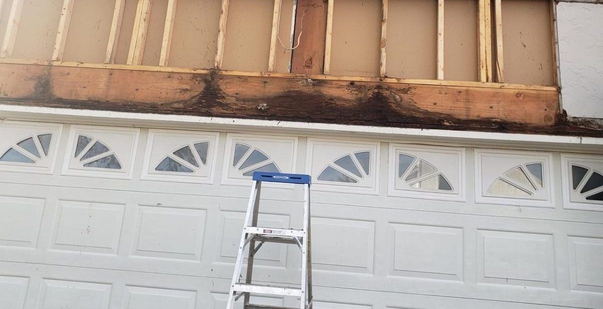 A ladder is sitting on the side of a garage door.