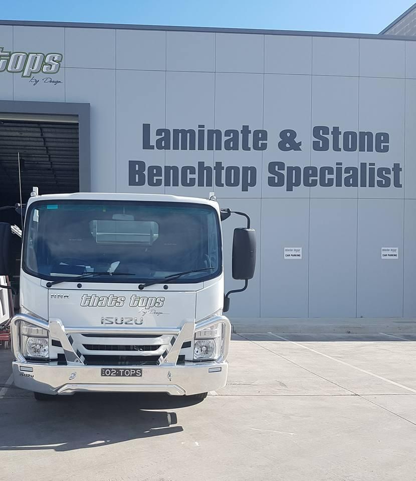 A White Truck Is Parked in Front of A Building that Says Laminate & Stone Benchtop Specialist — Thats Tops by Design in Gunnedah, NSW