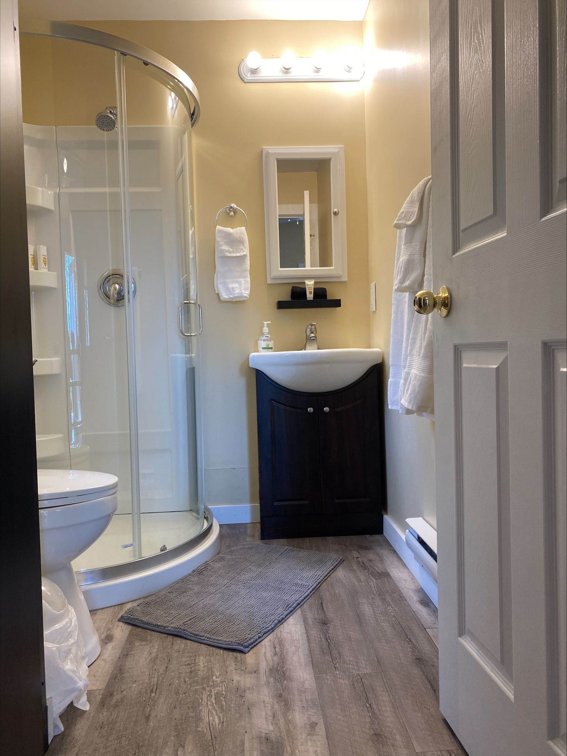 A bathroom with a toilet , sink , and shower.