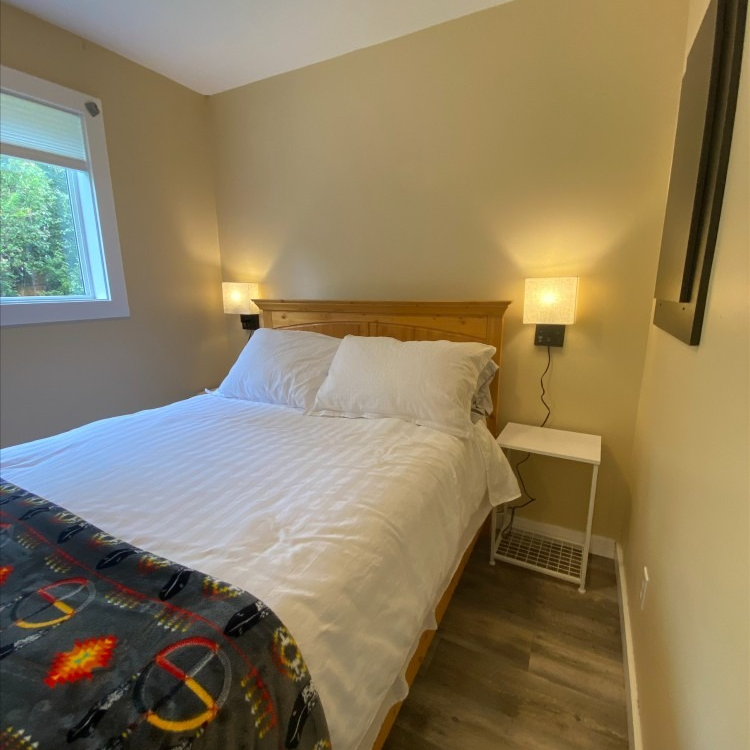 A bedroom with a bed and a nightstand