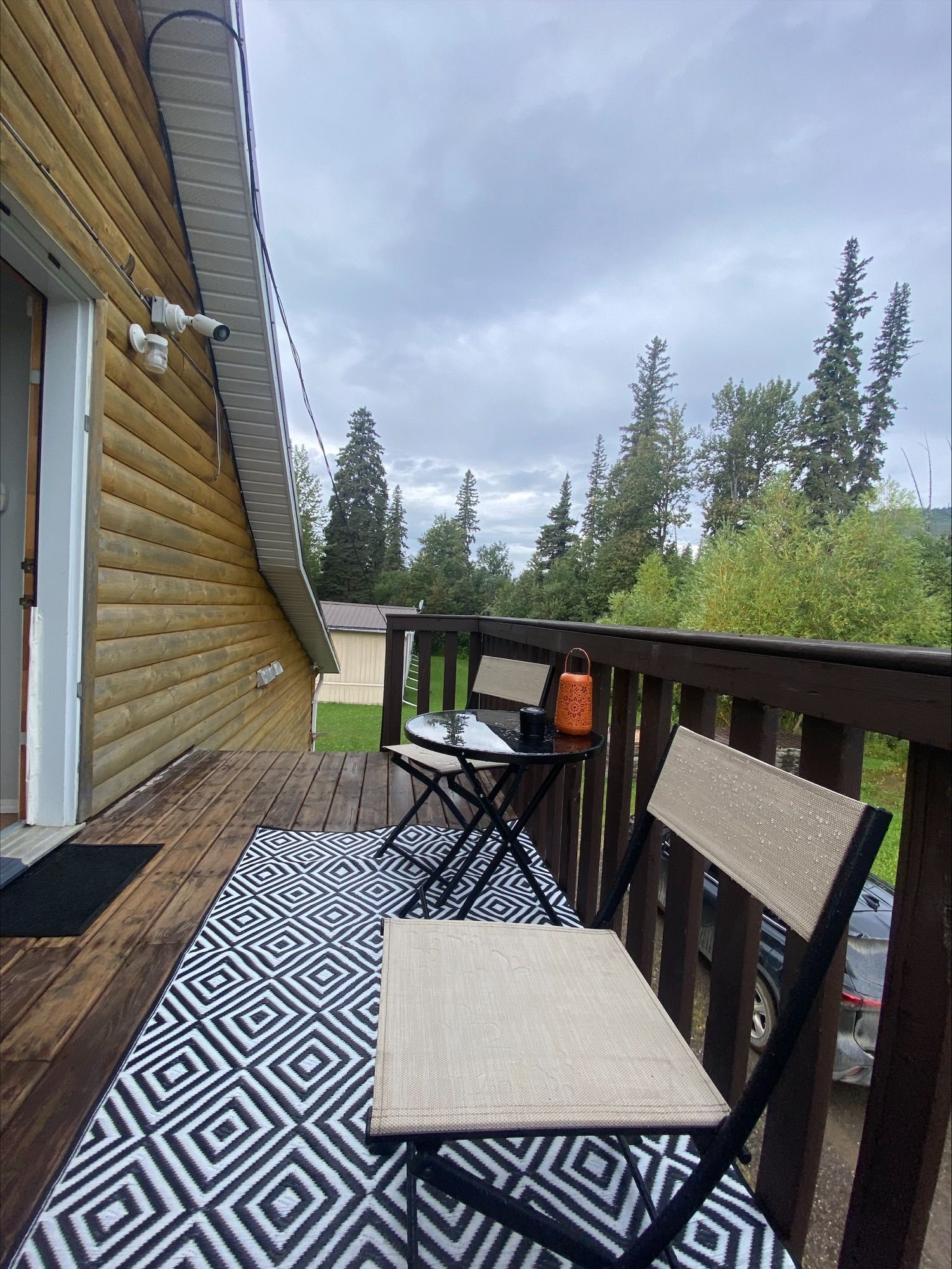 There is a chair and a table on the balcony of a house.