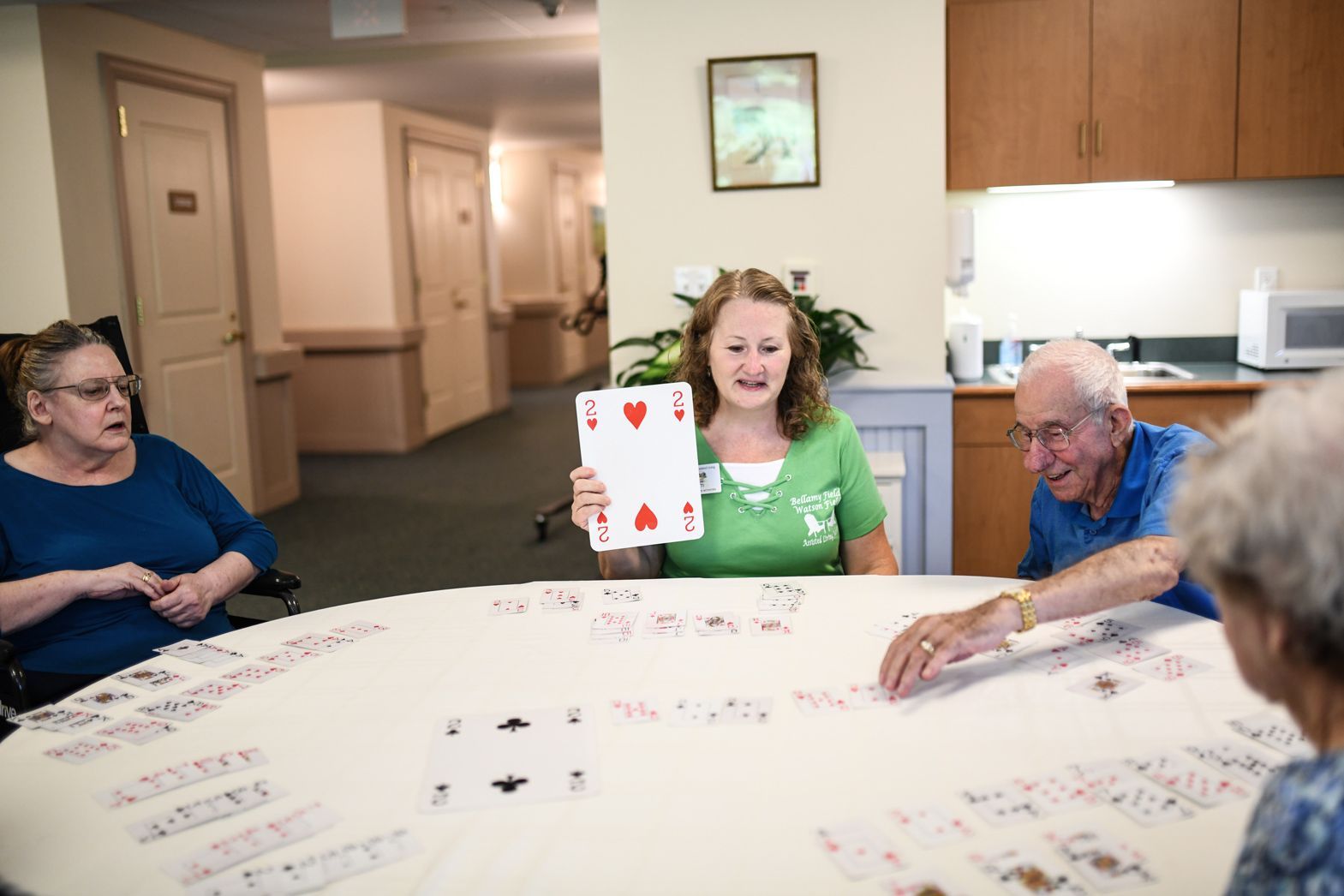 Caregiver engaging with residents during a group game session at Watson Assisted Living