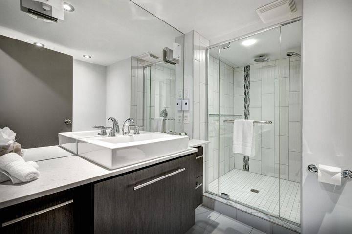 A bathroom with a sink and a walk in shower.