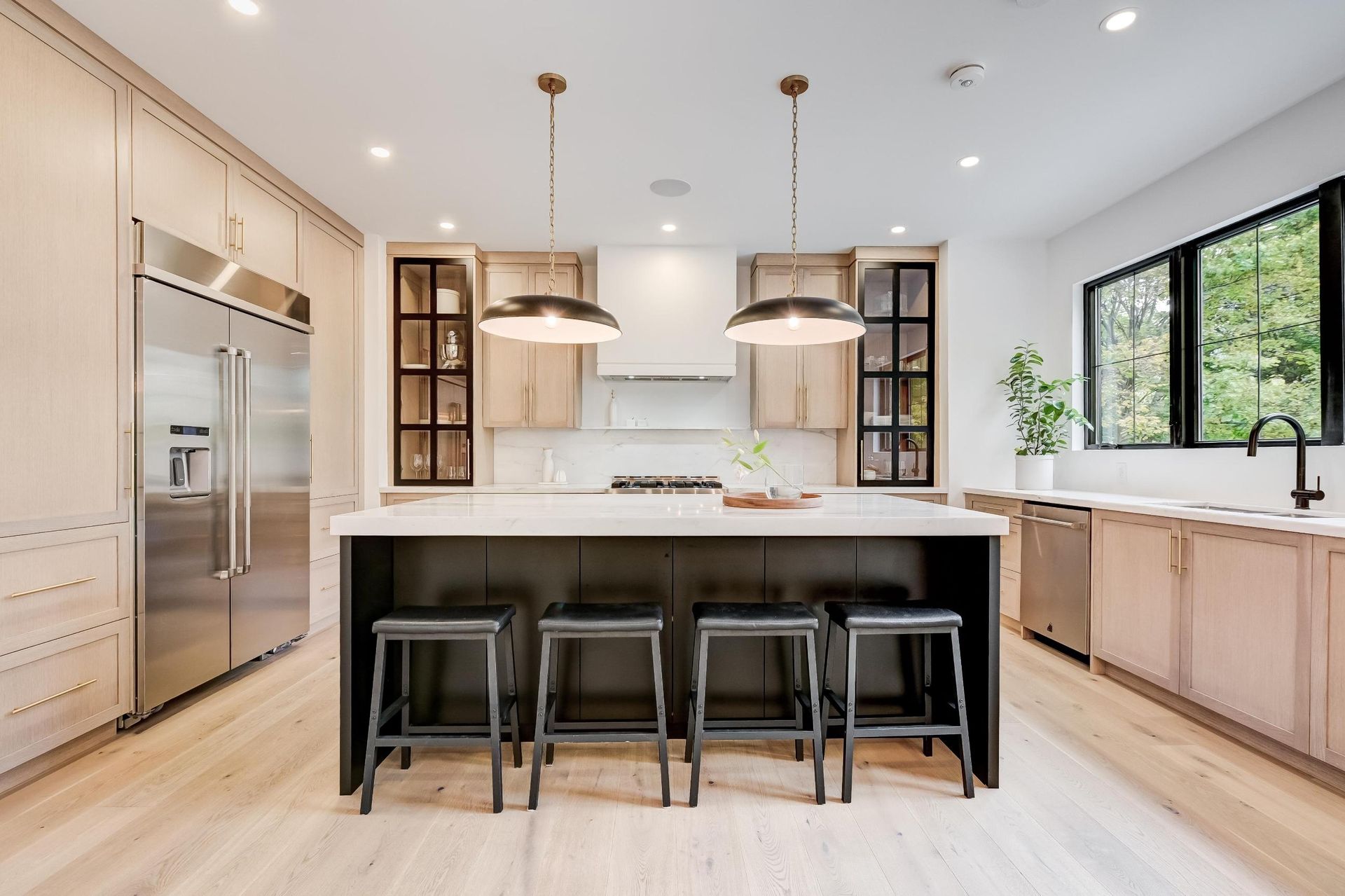 A kitchen with a large island and stools.
