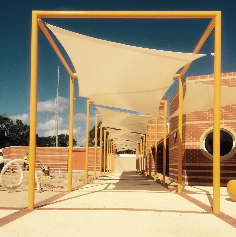 A brick building with a yellow frame and white shade