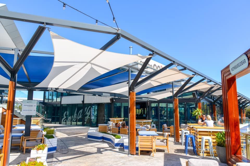 A restaurant with a lot of tables and chairs under umbrellas