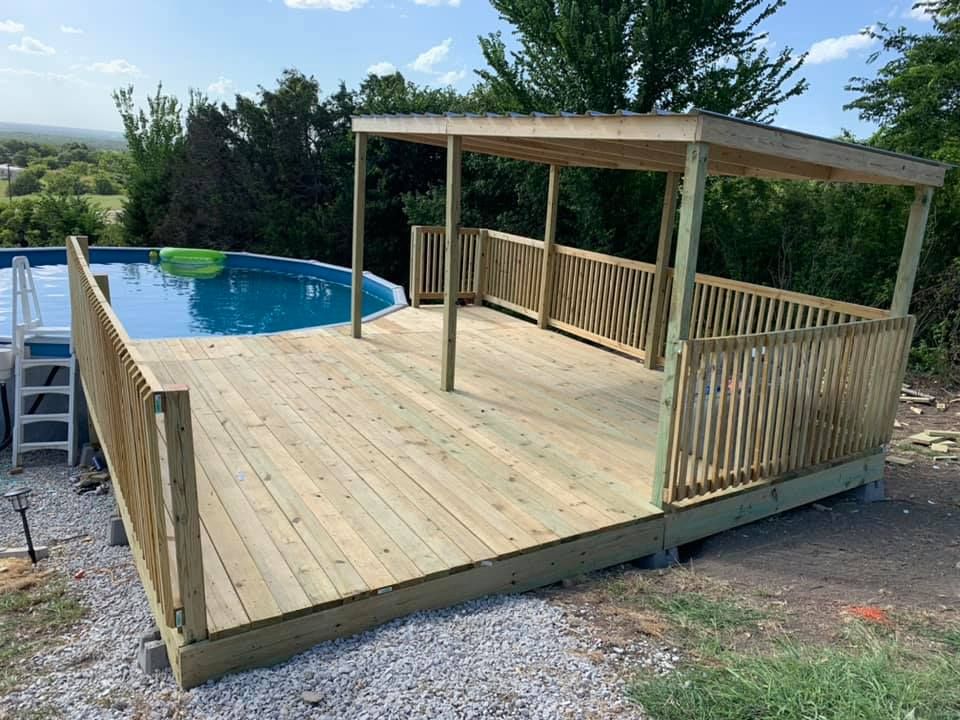 A side view of a new light-colored wooden privacy fence in a backyard during the day.