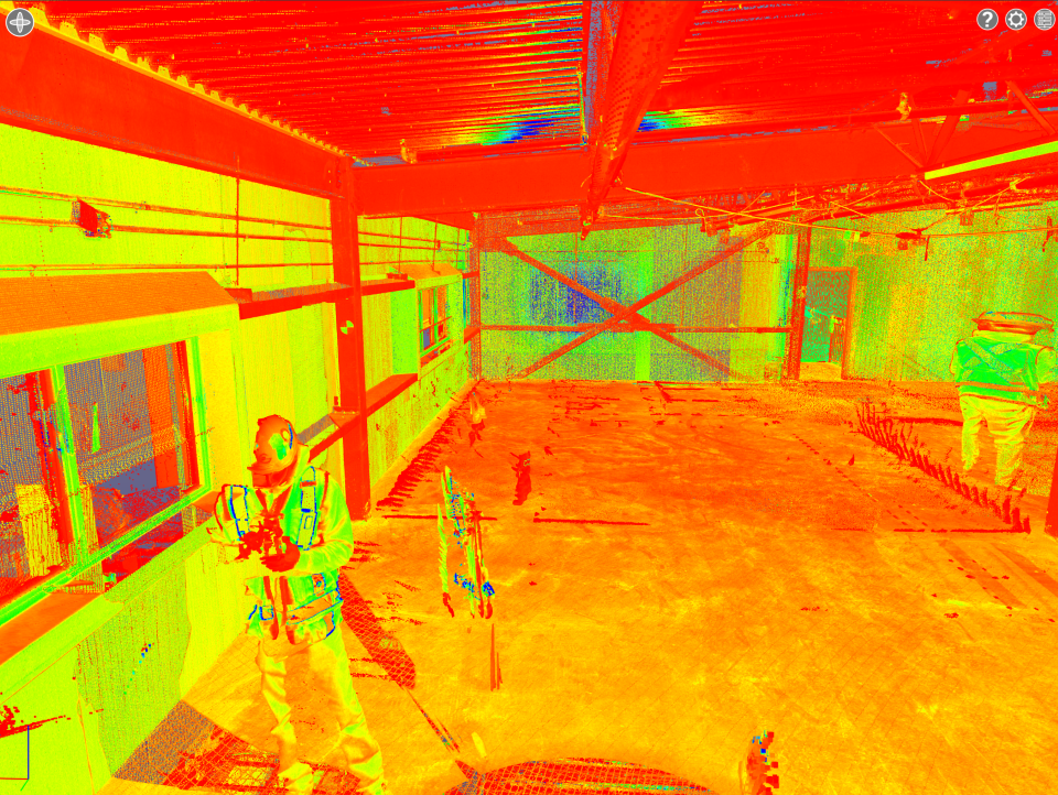 Enclos extérieur pour le bétail sous un toit rouge, vu de l'intérieur d'une structure ressemblant à une grange