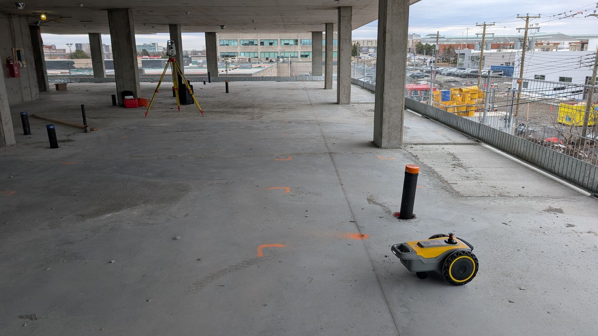 Robot de relevé au sol sur une dalle de béton en construction avec équipements de mesure.