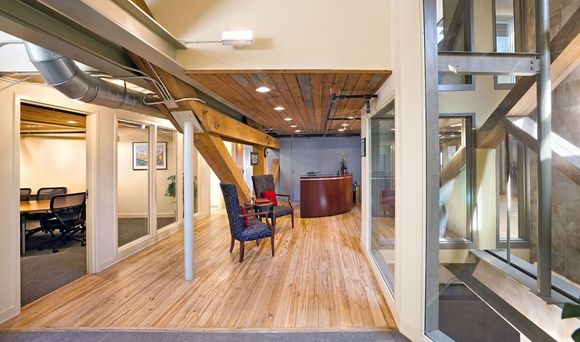 a hallway in a building with wooden floors and chairs