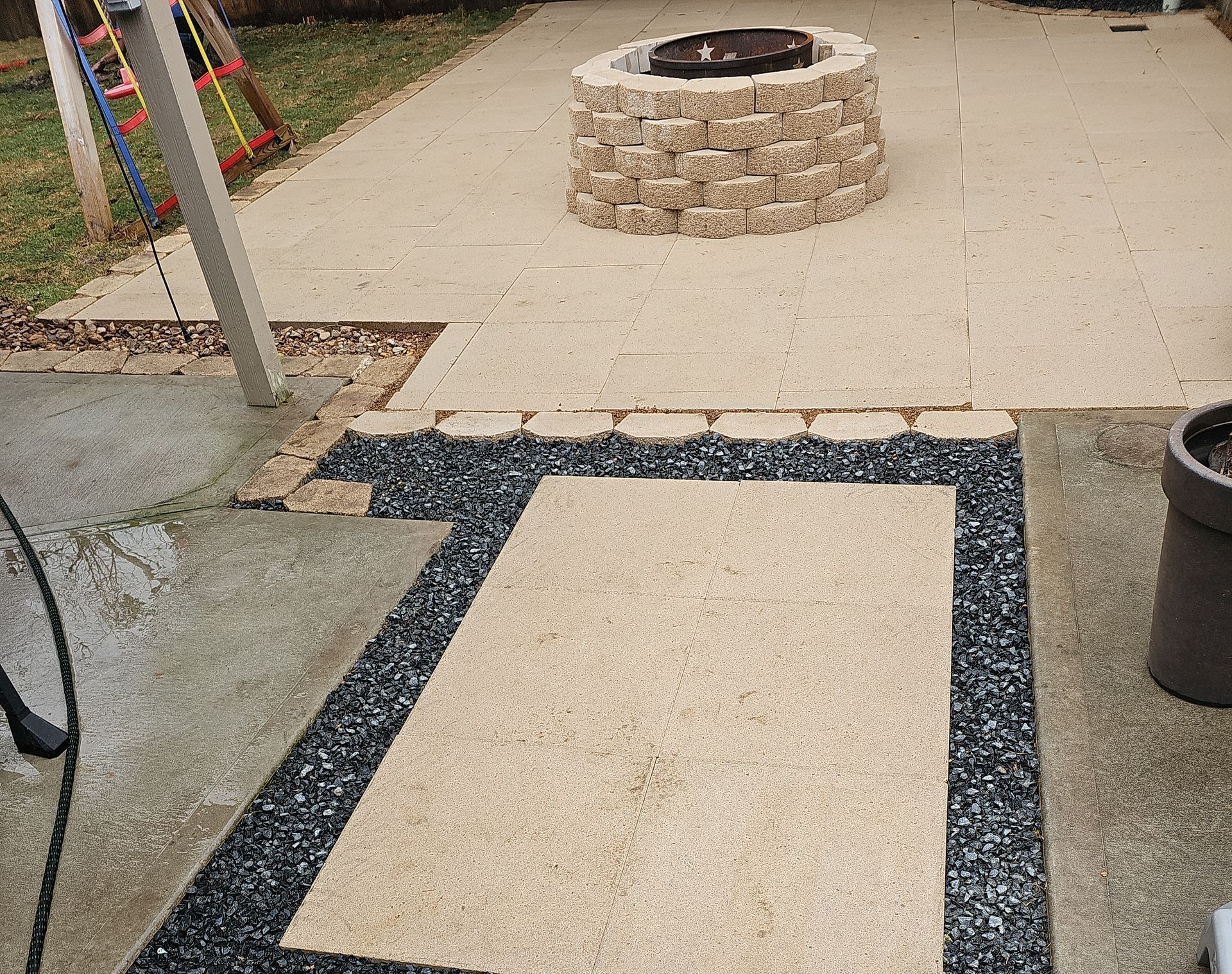 Patio with fire pit and gravel border.