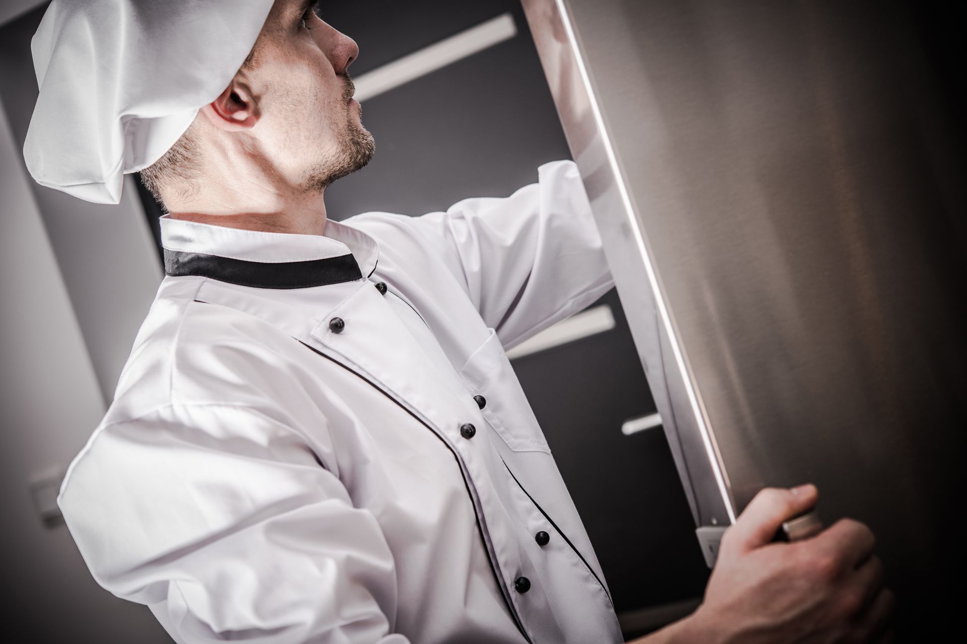 Opening a refrigerator door in a kitchen.