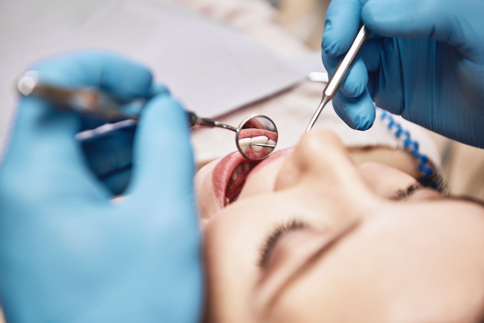 A woman is getting her teeth examined by a dentist.