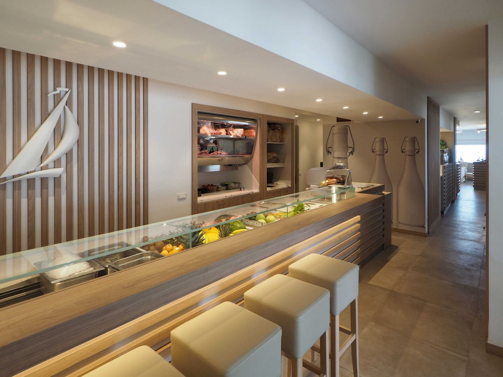Interni moderni del ristorante con posti a sedere al bancone, pannelli in legno e illuminazione calda.