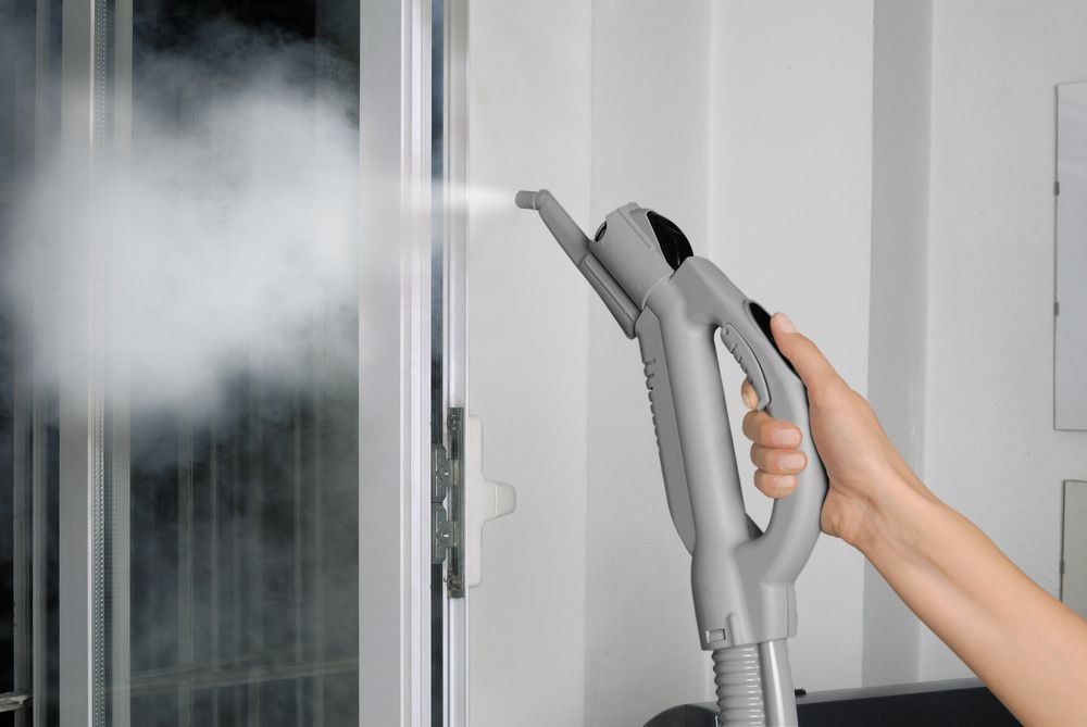 Person is Using a Steam Cleaner to Clean a Window — Happy Housekeepers in Gunnedah, NSW 