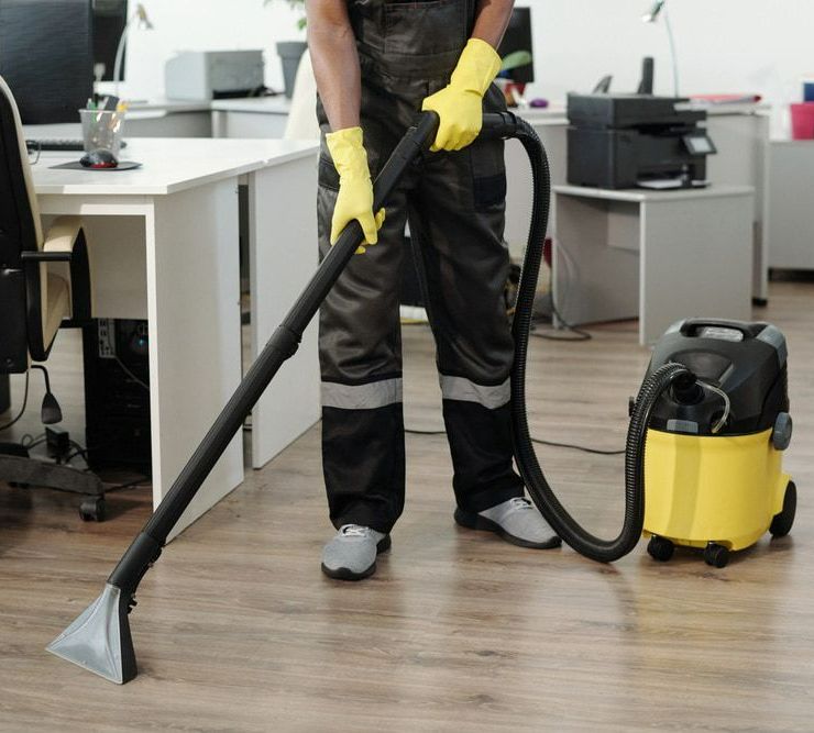 Man is Cleaning the Floor of an Office With a Vacuum Cleaner — Happy Housekeepers in Quirindi, NSW