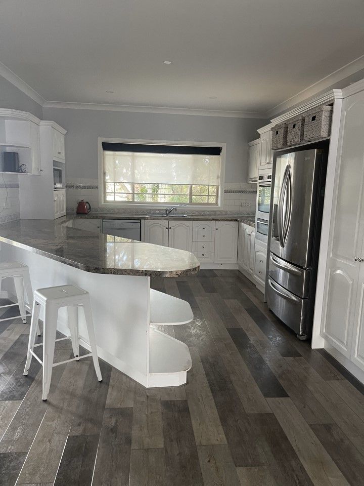 Kitchen With a Large Island, Stools, a Refrigerator and a Window — Happy Housekeepers in South Tamworth, NSW