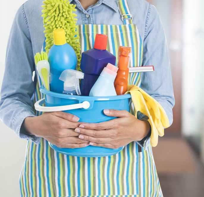 Woman in an Apron is Holding a Bucket of Cleaning Supplies — Happy Housekeepers in Quirindi, NSW