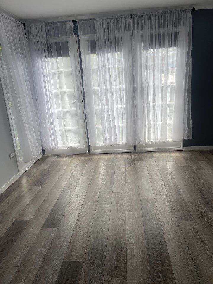 Living Room With Hardwood Floors and White Curtains — Happy Housekeepers in South Tamworth, NSW