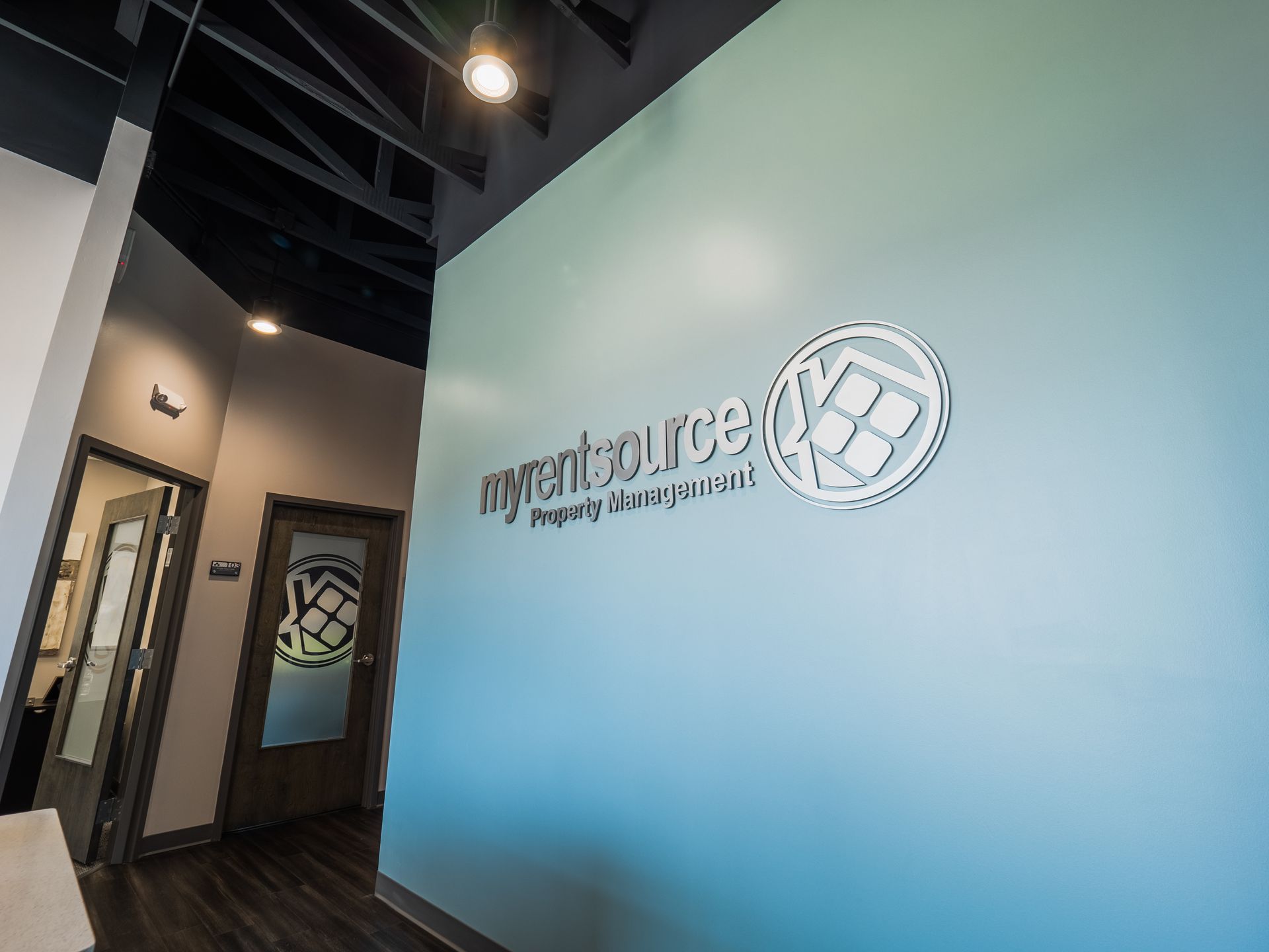 A hallway with a blue wall and a logo on it.