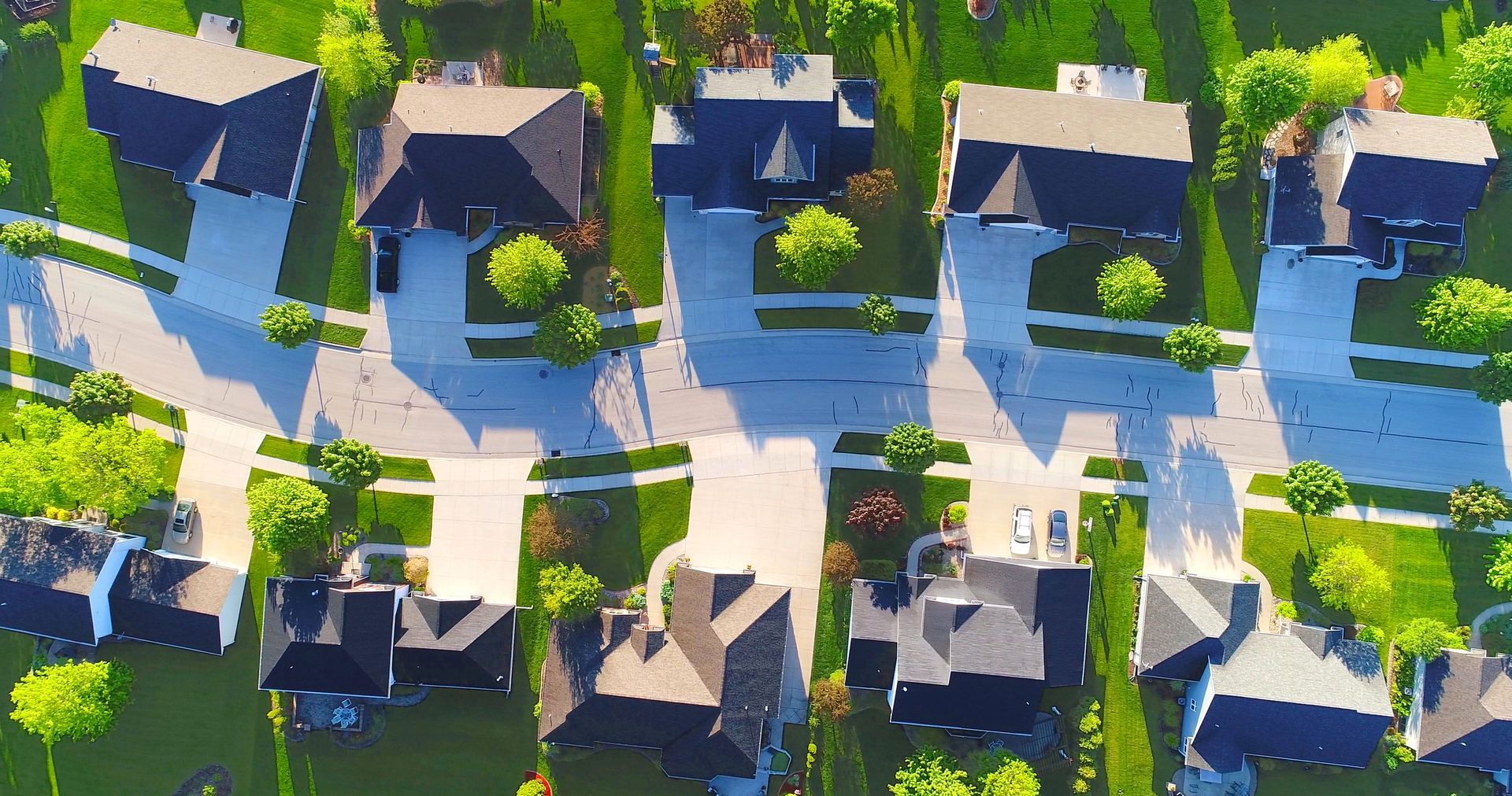 An aerial view of a residential neighborhood with lots of houses and trees.