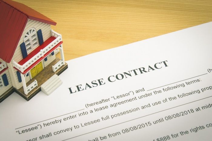 A model house is sitting on top of a lease contract