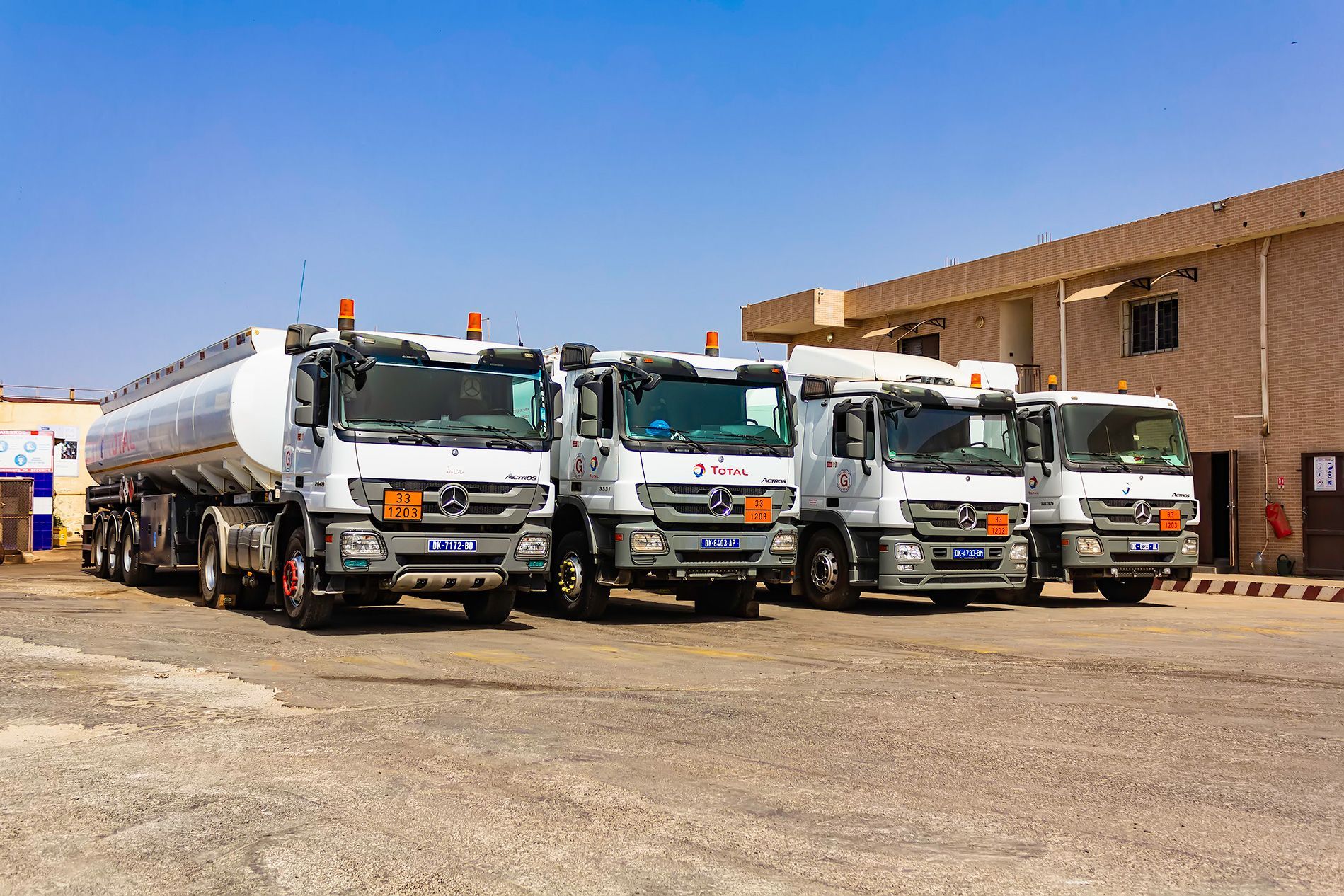 Une rangée de camions est garée devant un immeuble.
