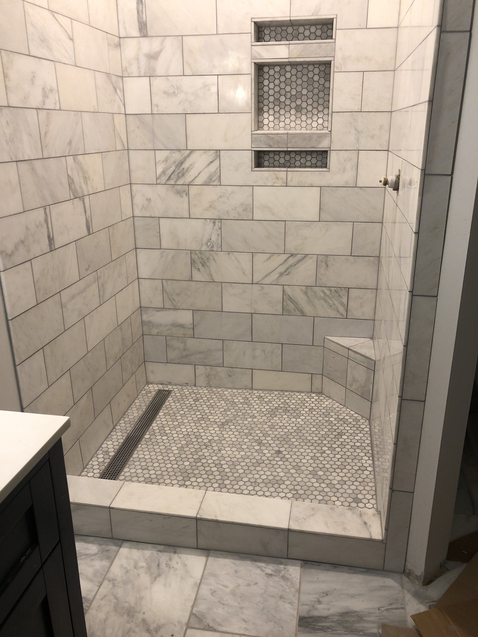 A bathroom with a walk in shower and a sink.
