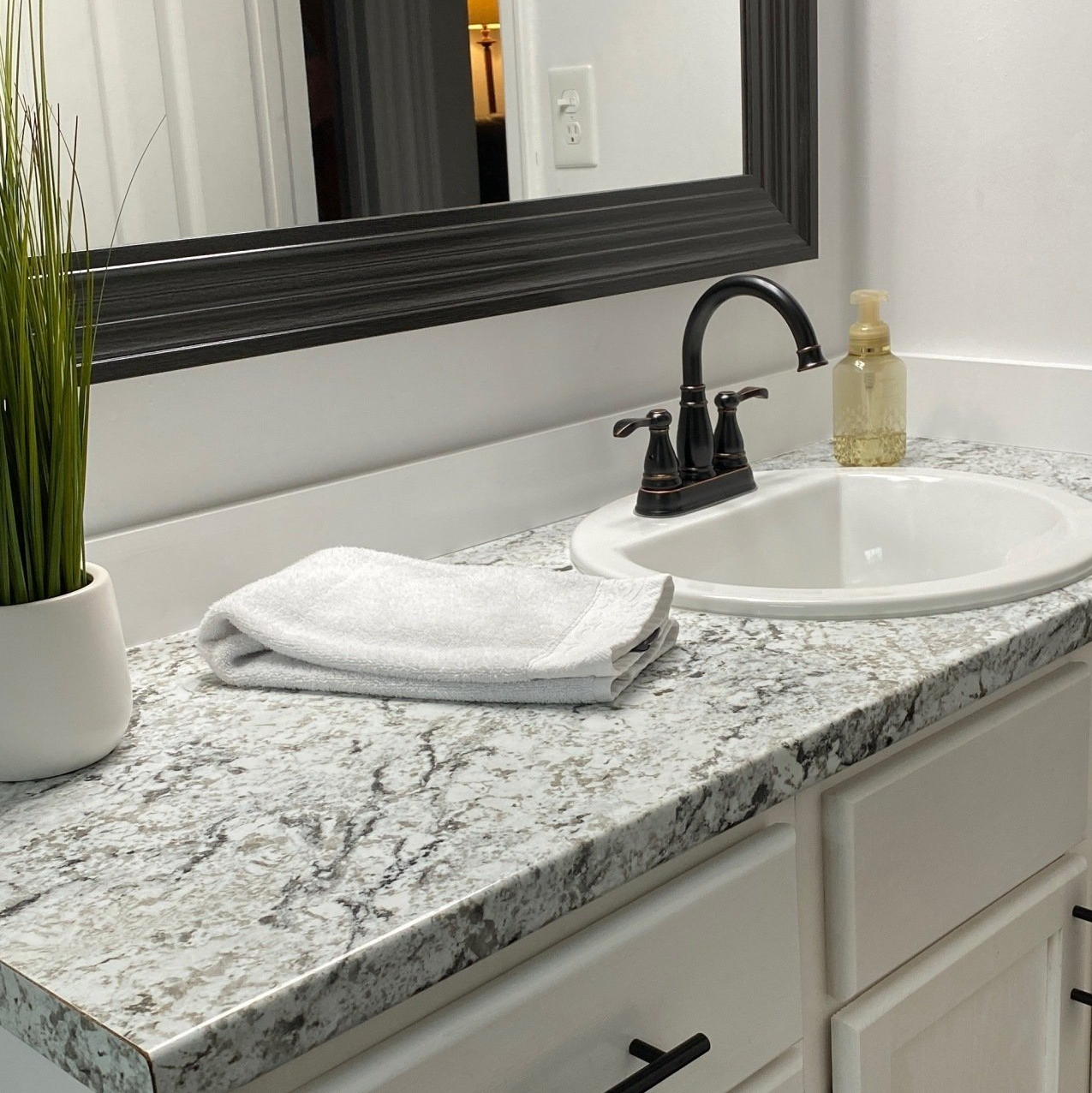 A bathroom counter with a sink and a mirror