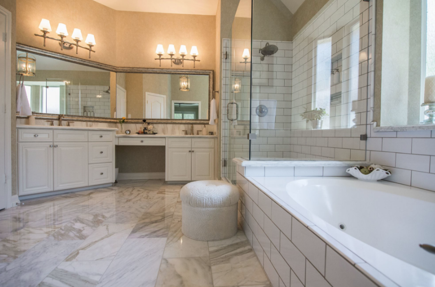A bathroom with a tub , sinks , mirrors and a walk in shower.