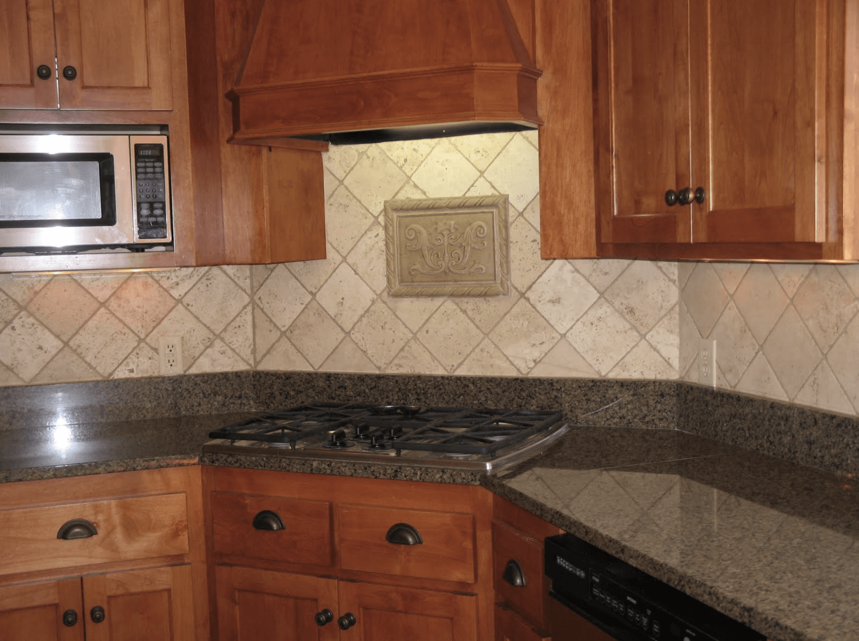 A kitchen with wooden cabinets and granite counter tops