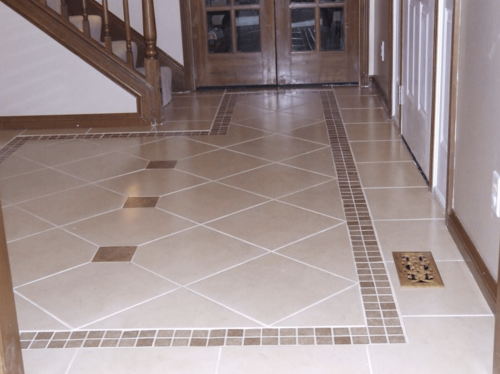 A hallway with a tiled floor and stairs in the background