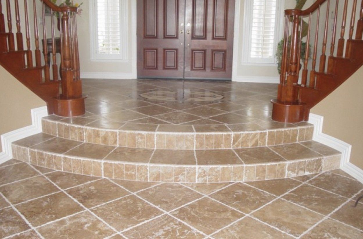 A hallway with a wooden staircase and a tiled floor.