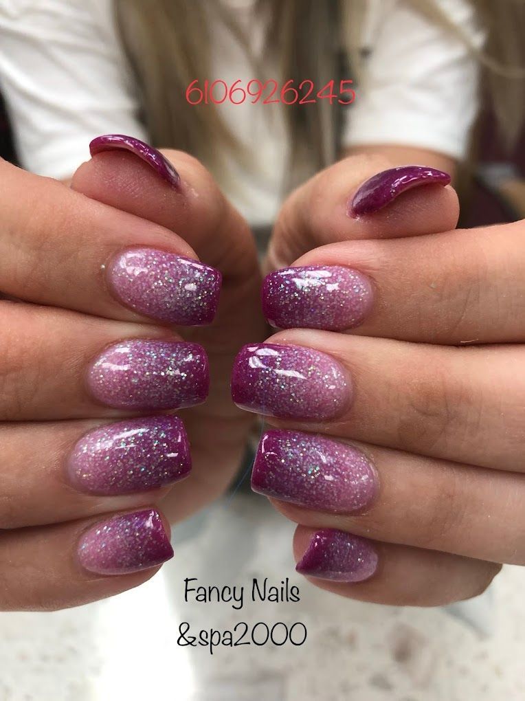 A close up of a woman 's hands with purple nails