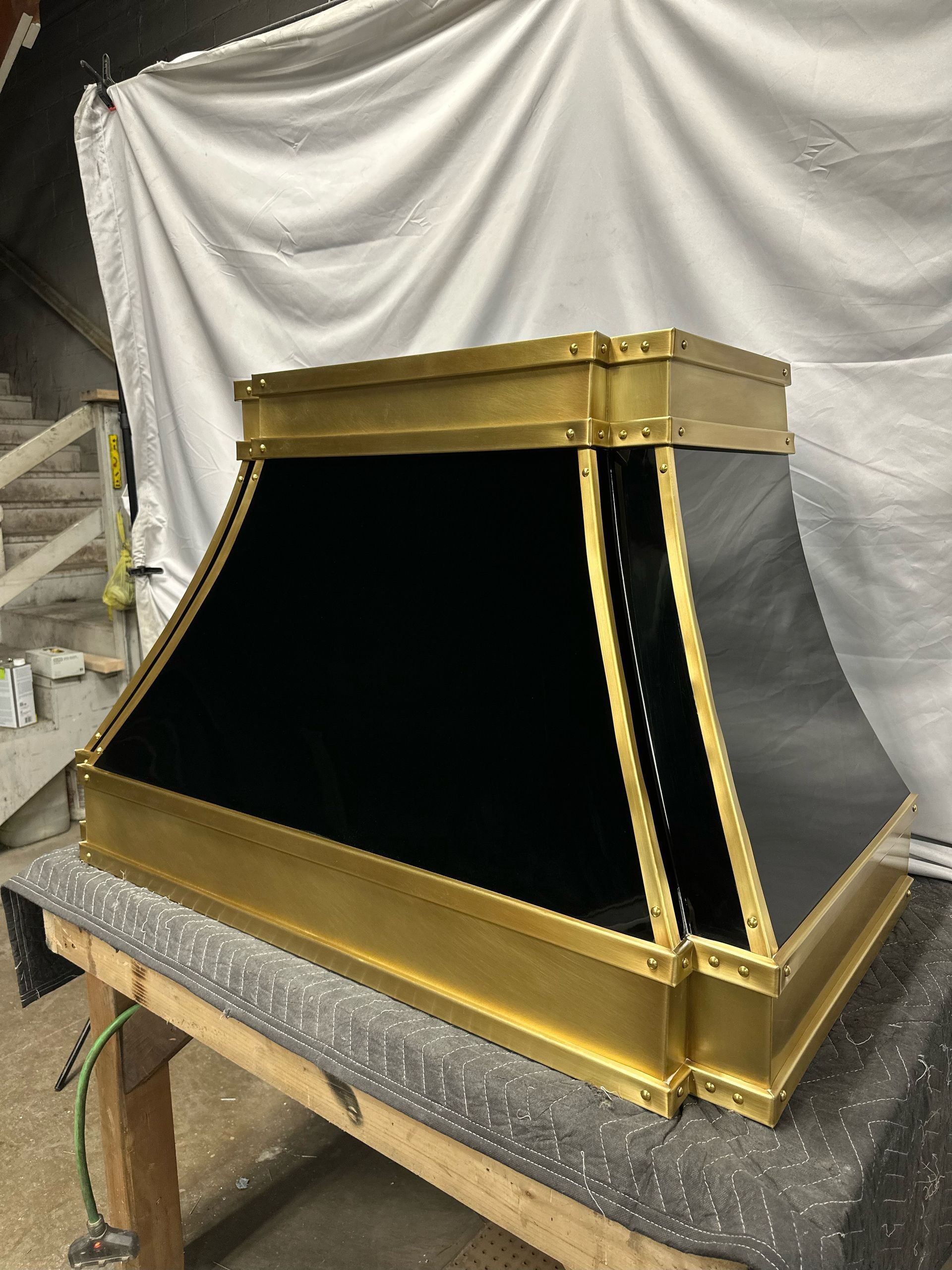 Gold and black decorative metal and fabric structure on a workbench in a workshop