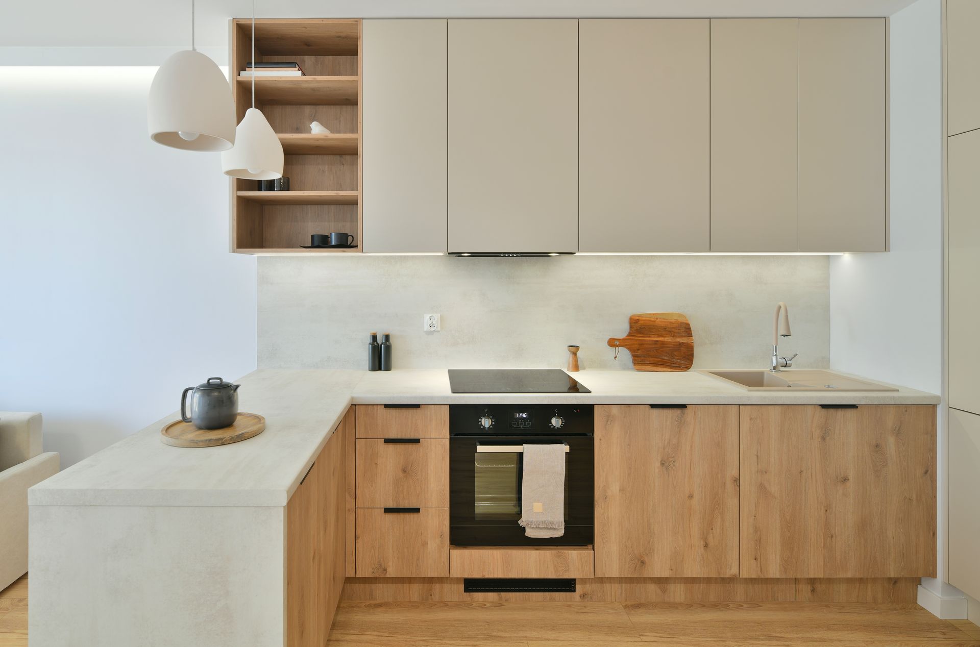 Minimalist modern kitchen with beige cabinets, light wood island, and white countertops