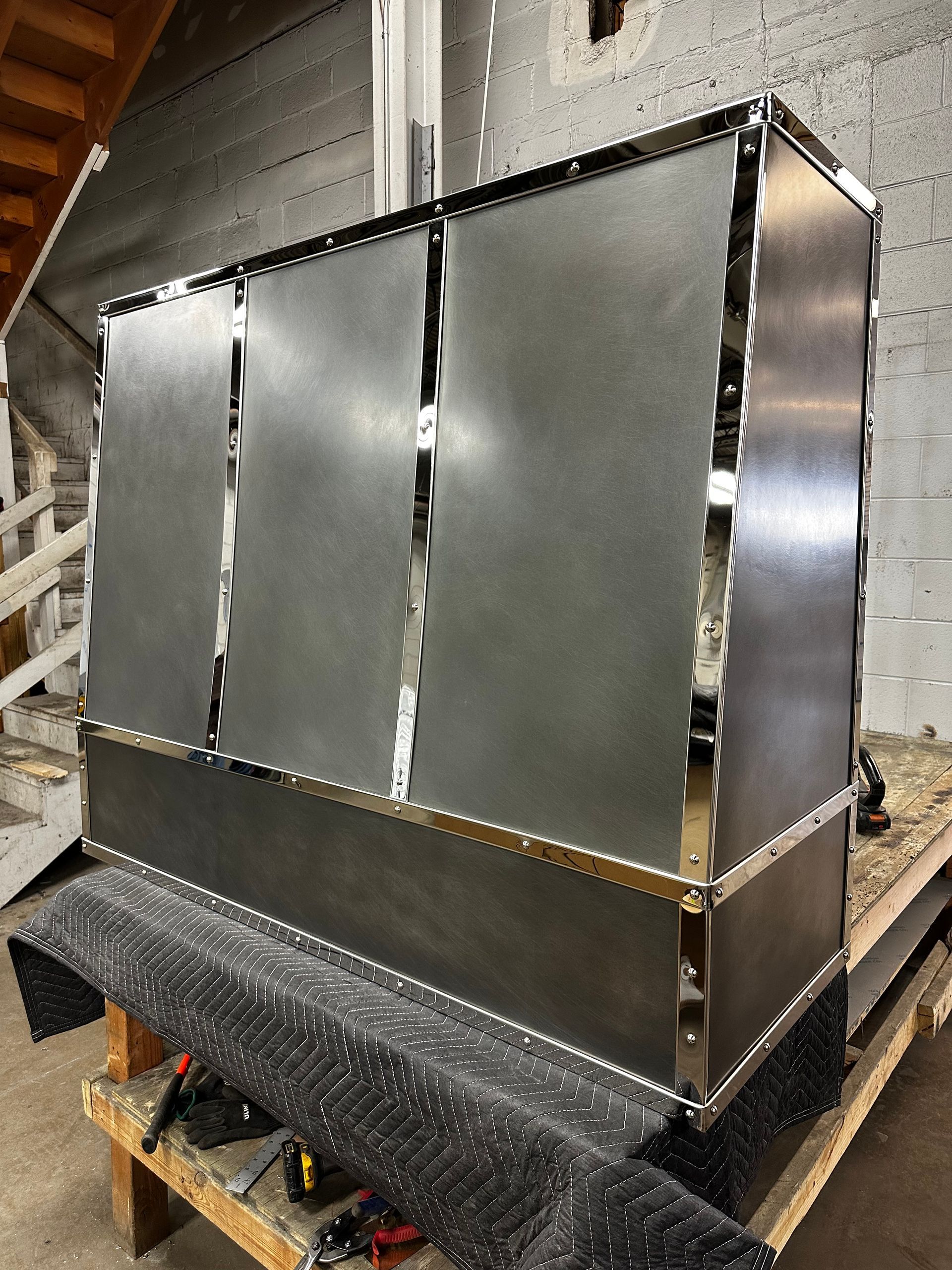 Large stainless steel industrial enclosure on a pallet in a warehouse