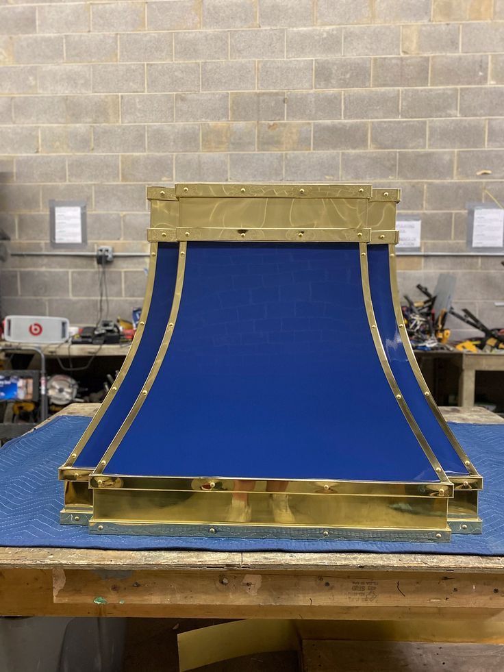Blue curved ramp prototype on a workbench in a workshop, framed with wood and metal trim