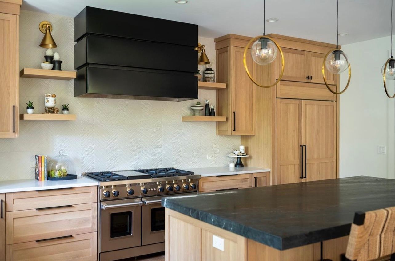 Modern kitchen with wood cabinets, black range hood, island, and pendant lights