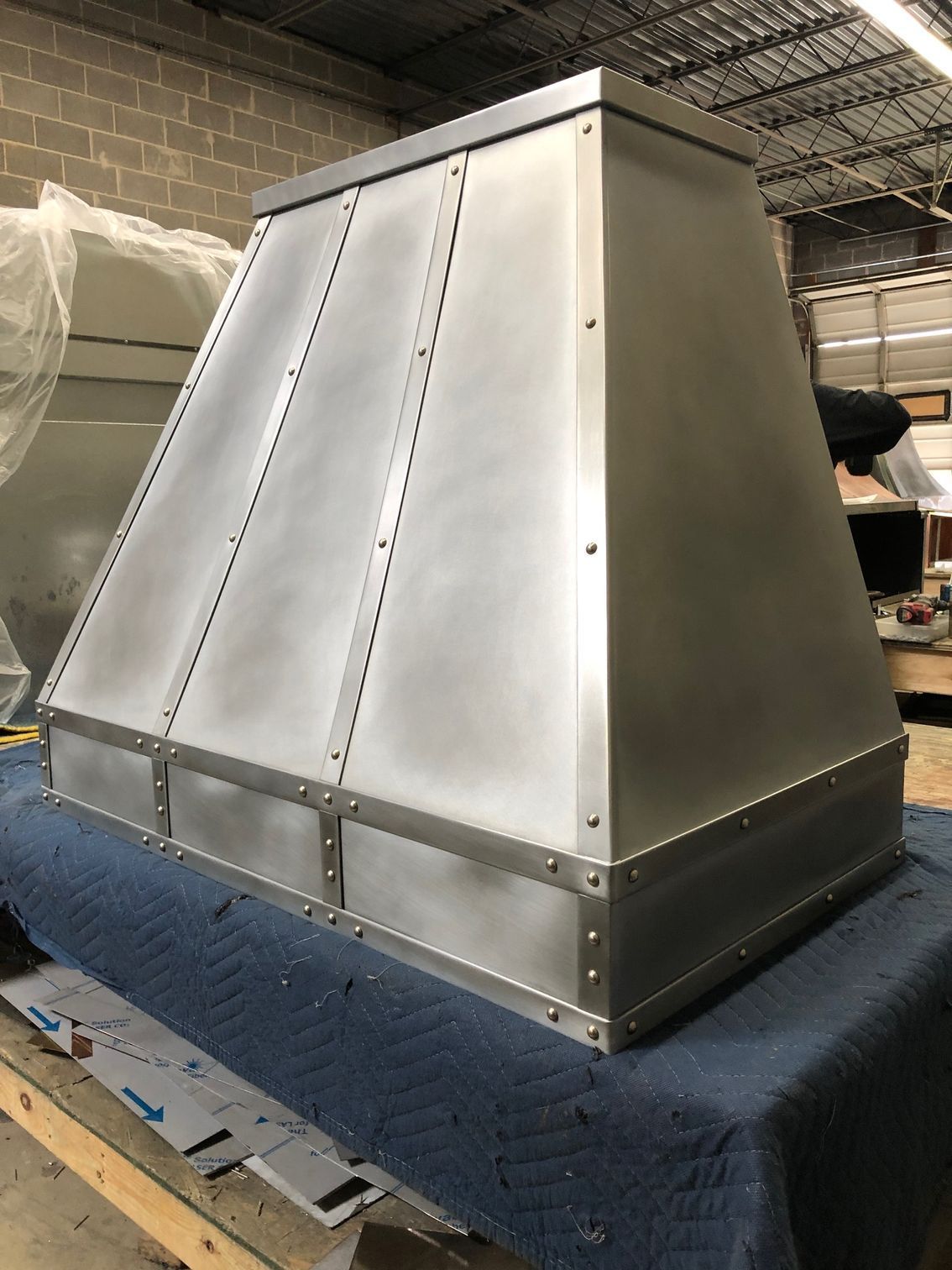 Stainless steel ventilation hood on a workbench in an industrial workshop