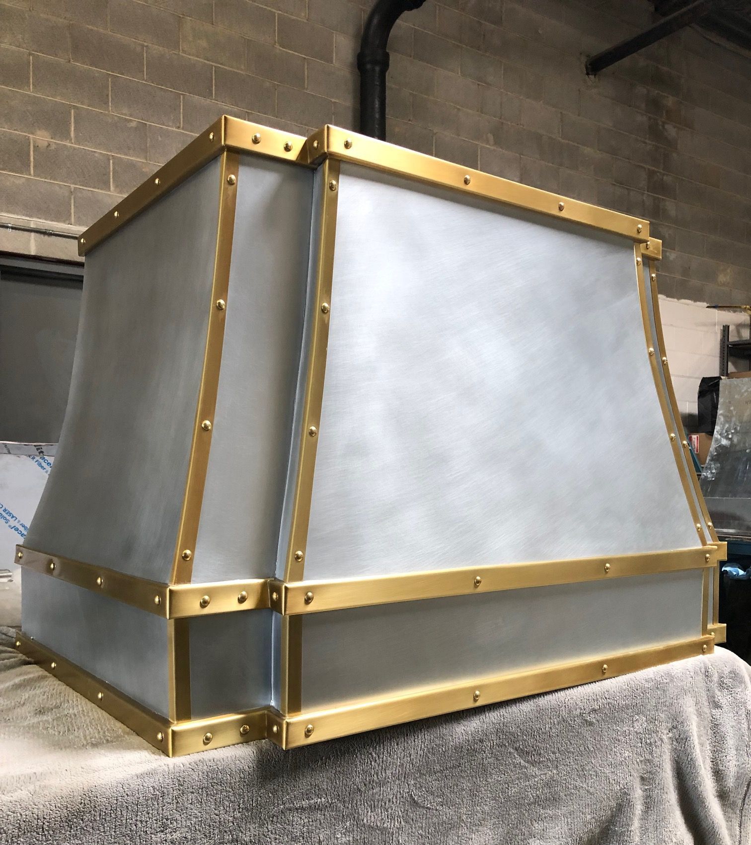 Gold-framed frosted panel box or enclosure on a gray cloth in an industrial workshop