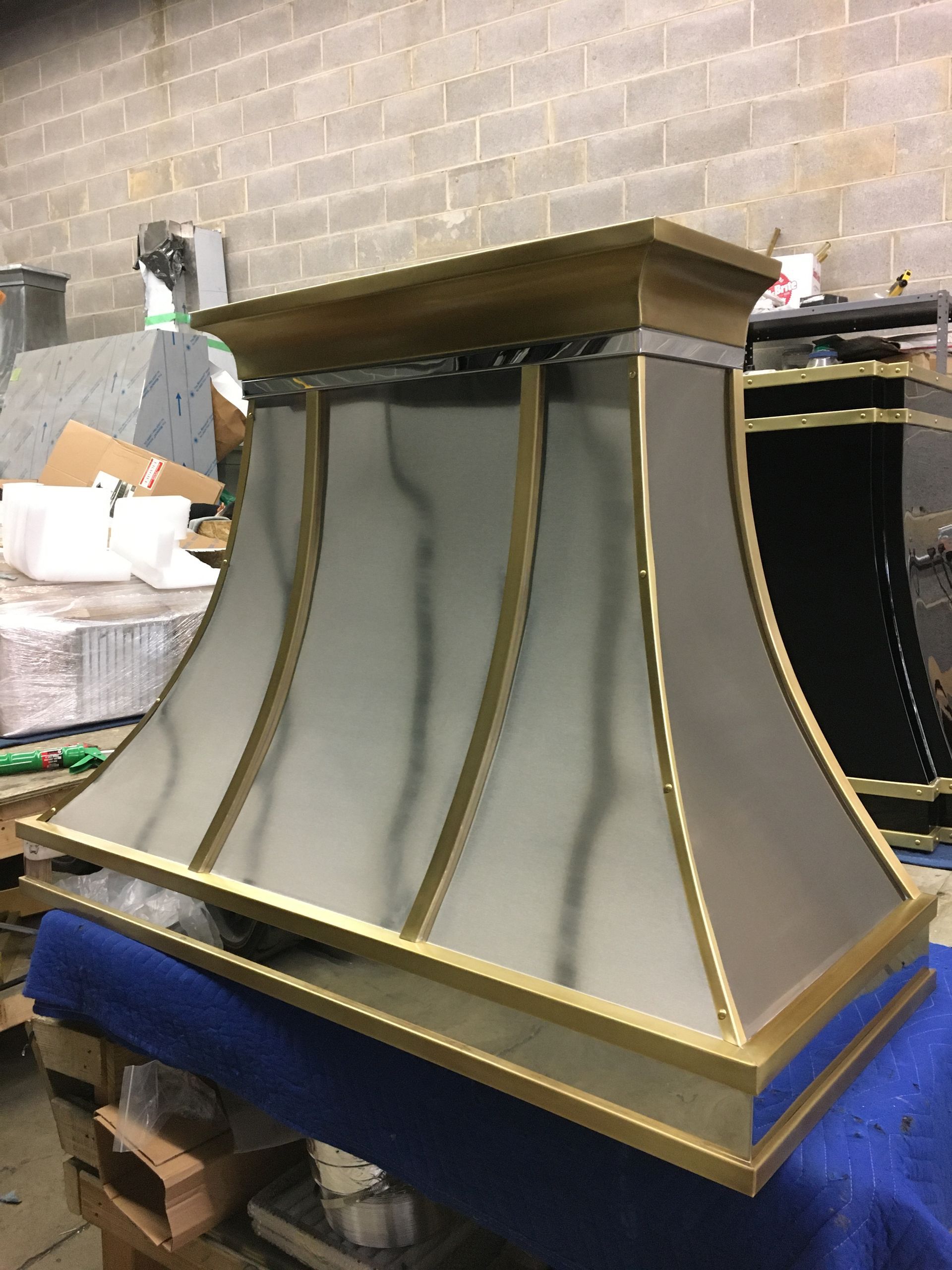 Large decorative metal pedestal with gold trim and blue base in a workshop