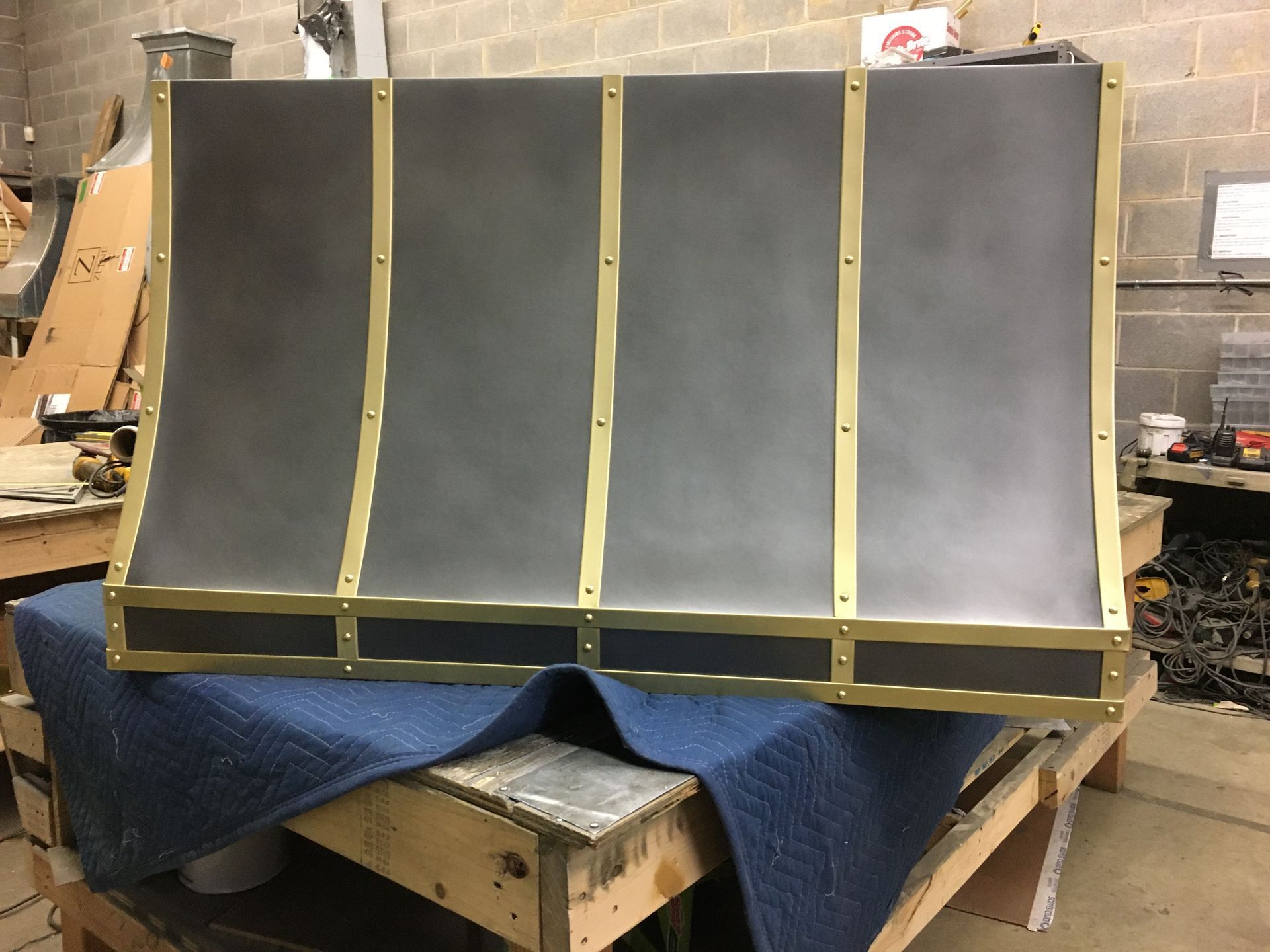 Dark gray panel on a workbench, reinforced with yellow tape in a workshop setting