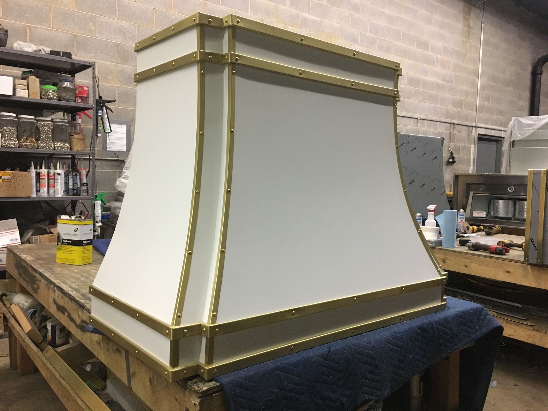 White-and-gold decorative furniture piece on a workbench in a workshop