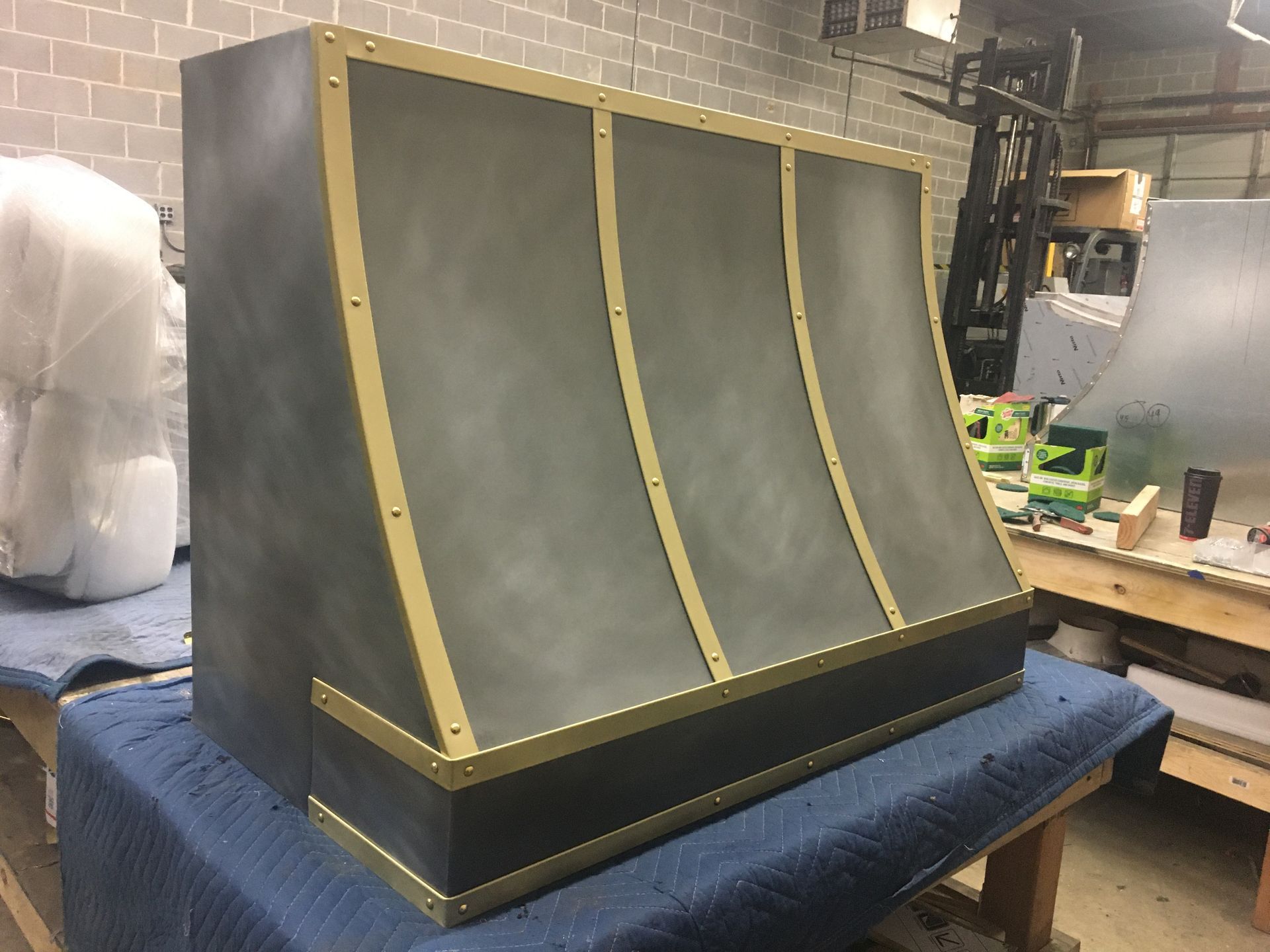 Black and gold curved display cabinet on a workbench in a workshop