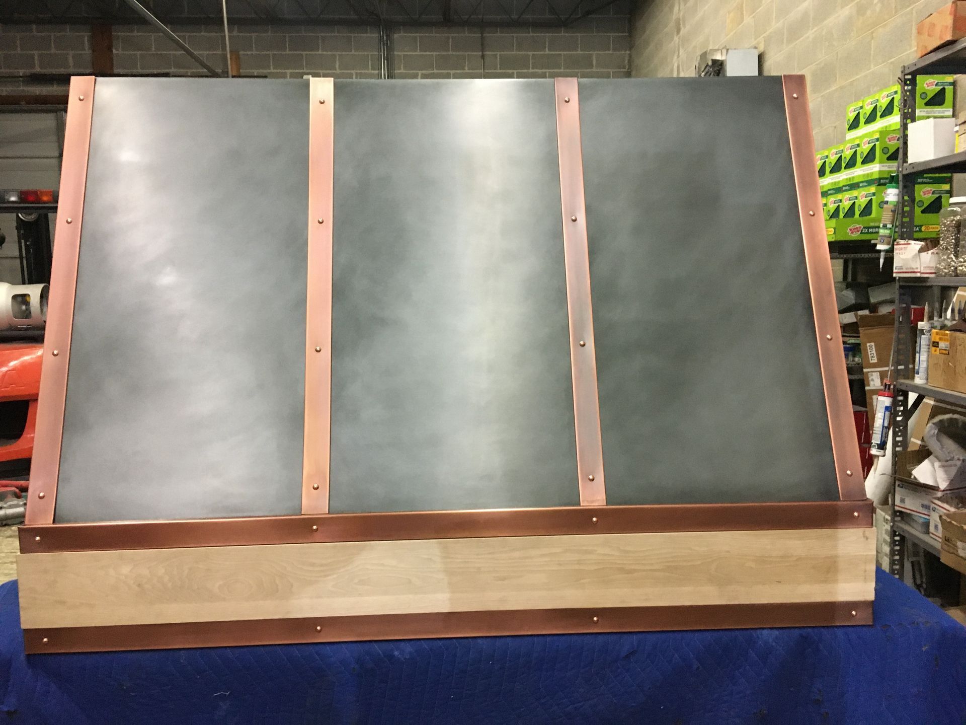 Large wooden-and-metal panel leaning upright in a warehouse aisle